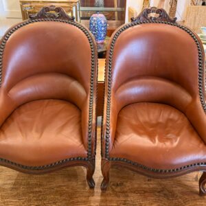 Paire de fauteuils en cuir et noyer sculpté