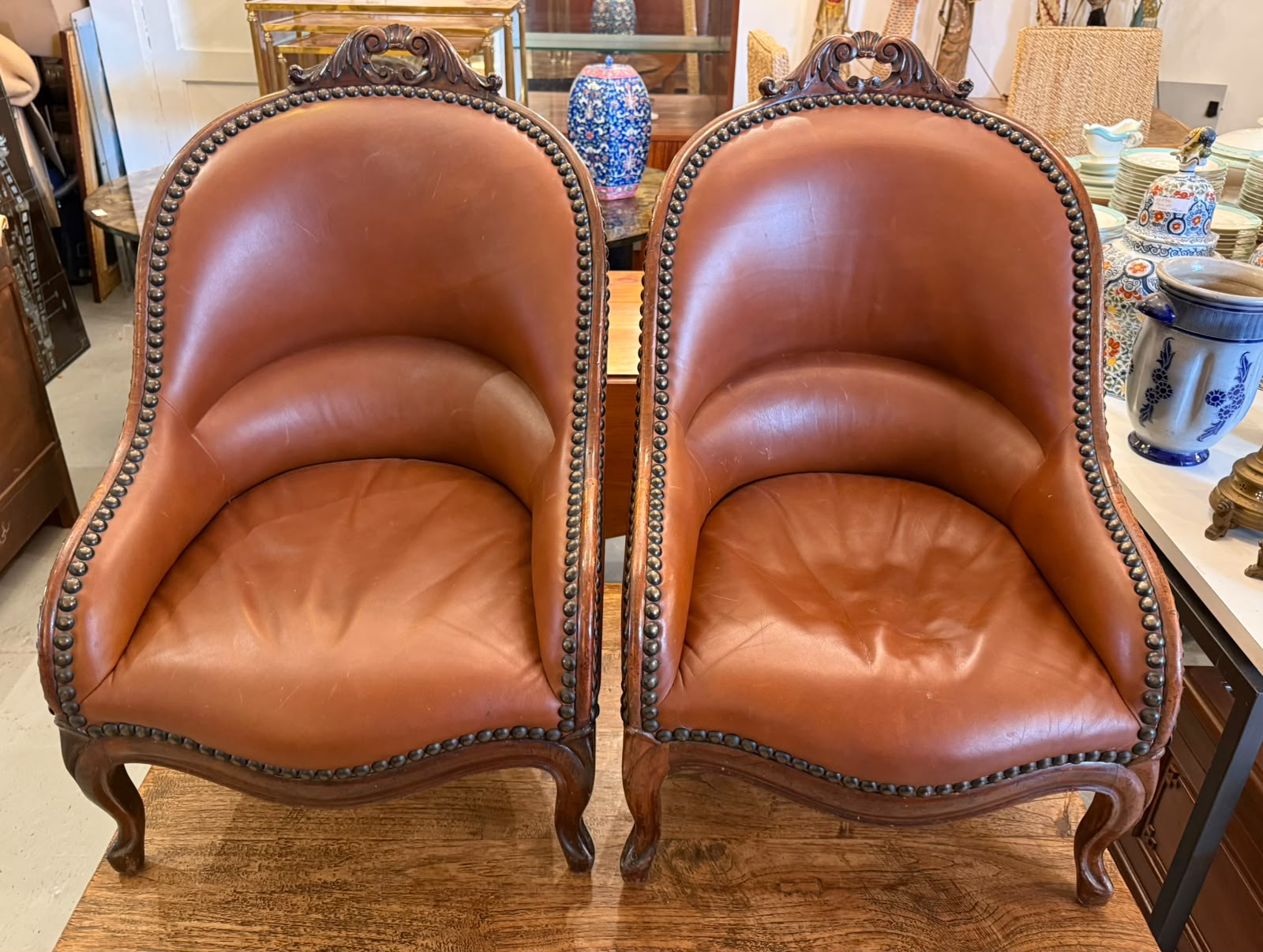 Paire de fauteuils en cuir et noyer sculpté