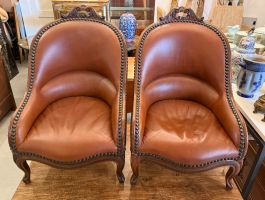 Paire de fauteuils en cuir et noyer sculpté